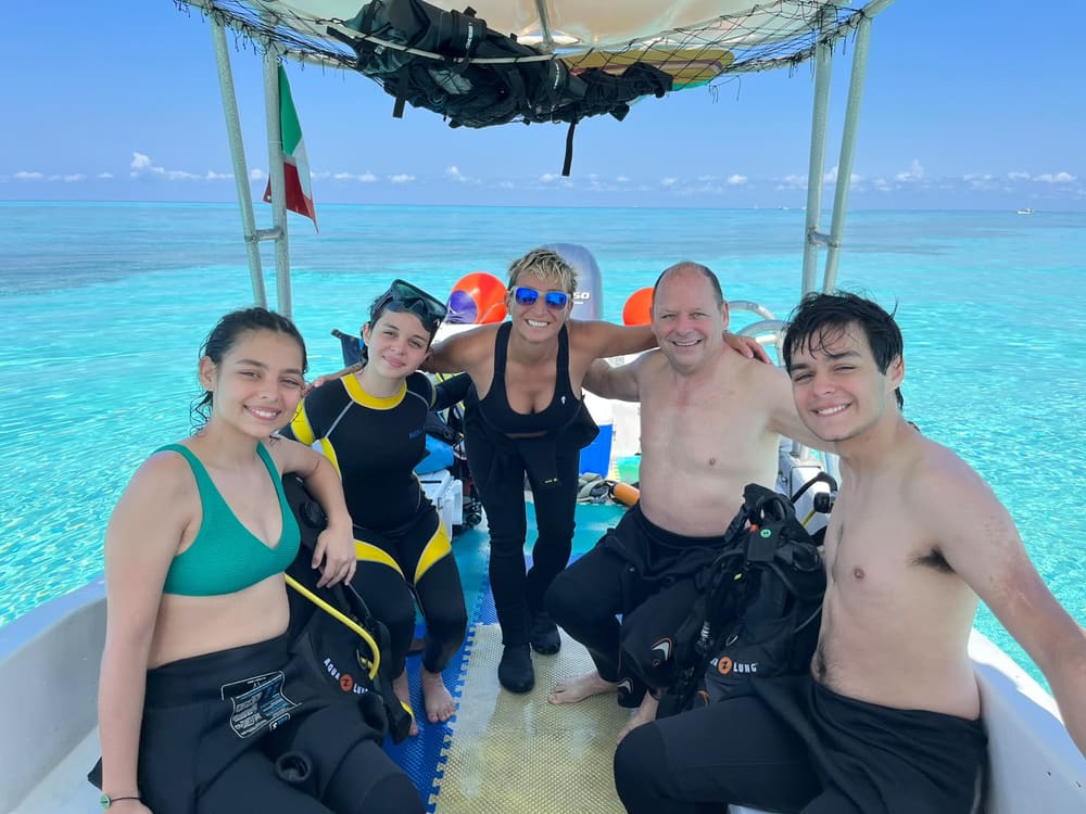 A family of five on the dive boat over turquoise shallows in Cozumel